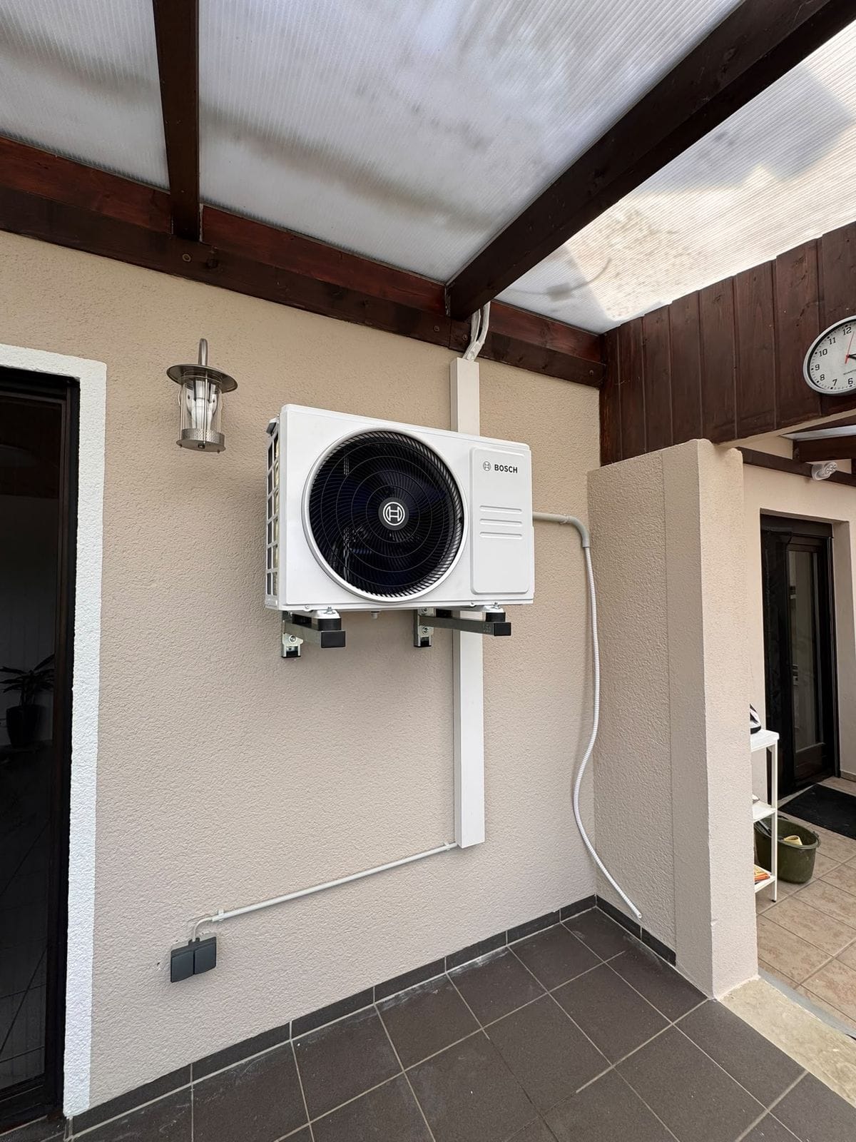 Außengerät auf einer Wandkonsole unter der Terrassenüberdachung, Leitungen sauber im Kanal geführt